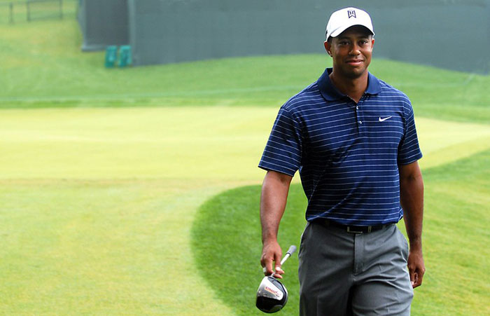 Tiger Woods walking in golf field 