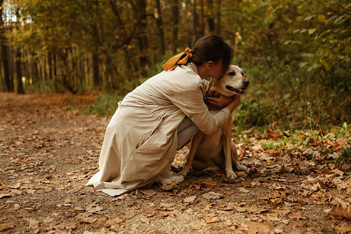 Woman hugging dog outside 