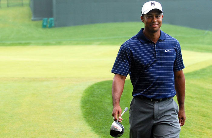 Tiger Woods walking in golf field 