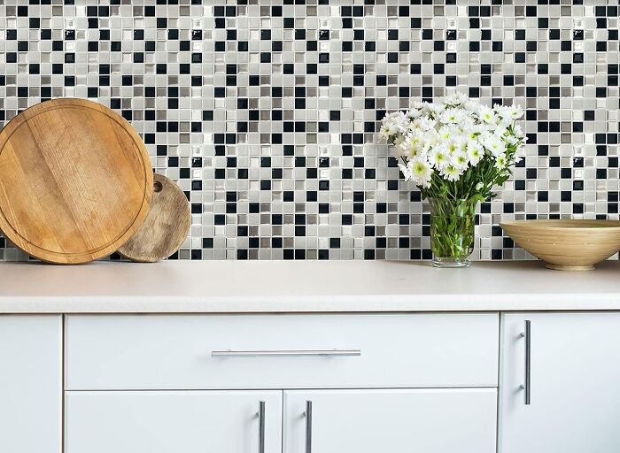 Kitchen with metallic checkerboard tile backsplash and cupboards