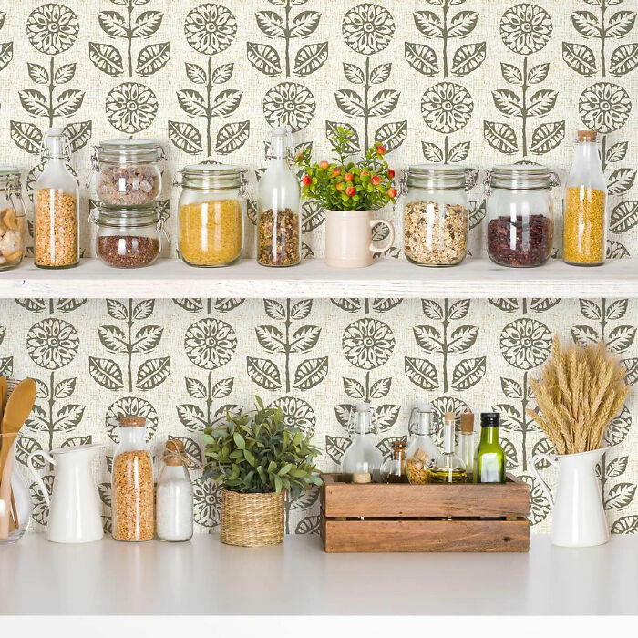 Kitchen with flower wallpaper and white shelves with spices