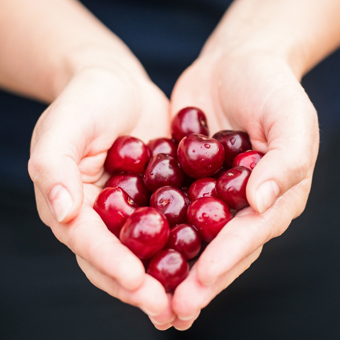 Person holding cherries 