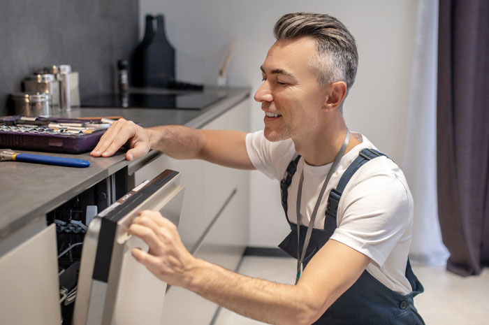 A man sitting on his haunches and examining a granite countertop