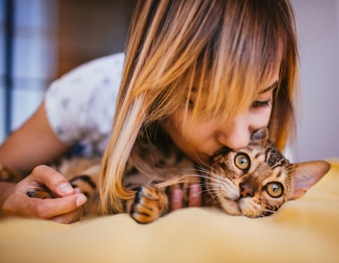 woman kissing toyger cat