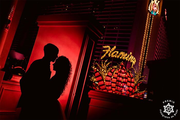 Silhouetted couple embracing in front of neon lights for a stunning wedding photo.