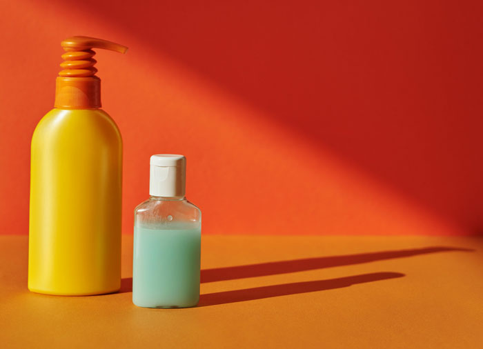 bottles with cosmetics on an orange background