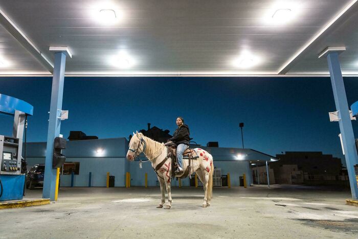 I Took A Photo Of A Young Woman Sitting On A Horse In A Gas Station