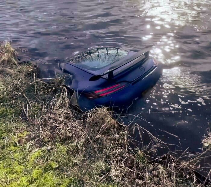 Luxury car submerged in water, representing an unfortunate and expensive incident.