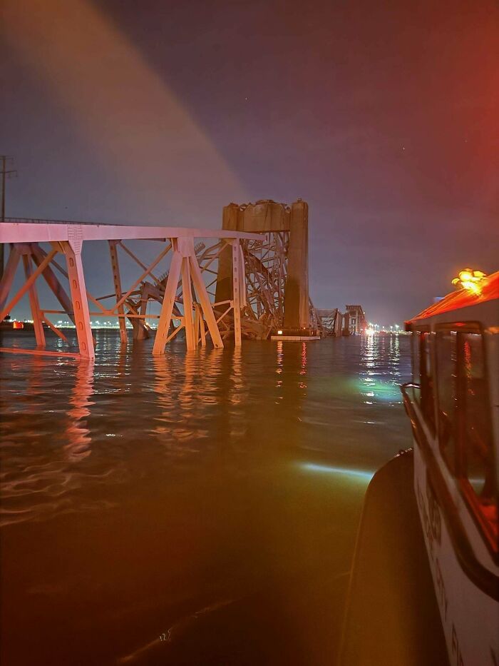 Collapsed bridge over water at night, a likely expensive incident with significant repair costs.