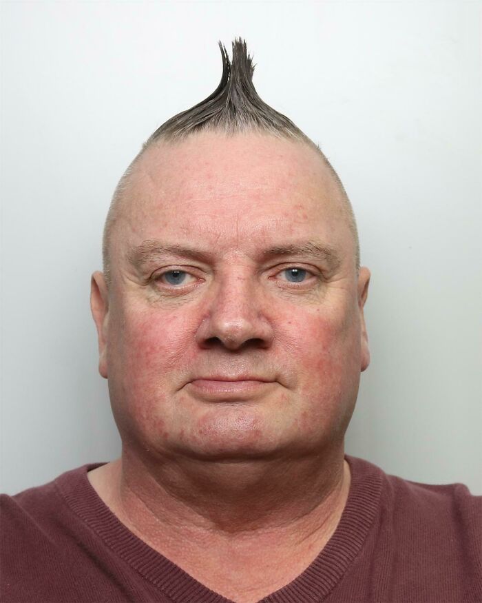 Man with a unique hairstyle featuring a single vertical spike, highlighting a hair accident.