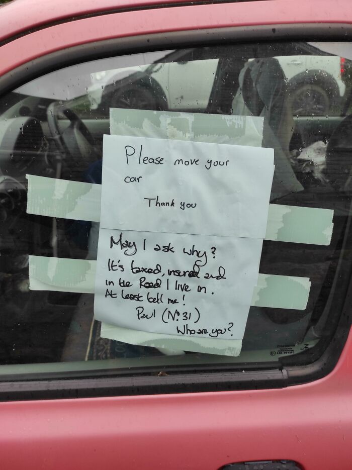 Note taped to car window with humorous British response about parking, asking for an explanation and identity.