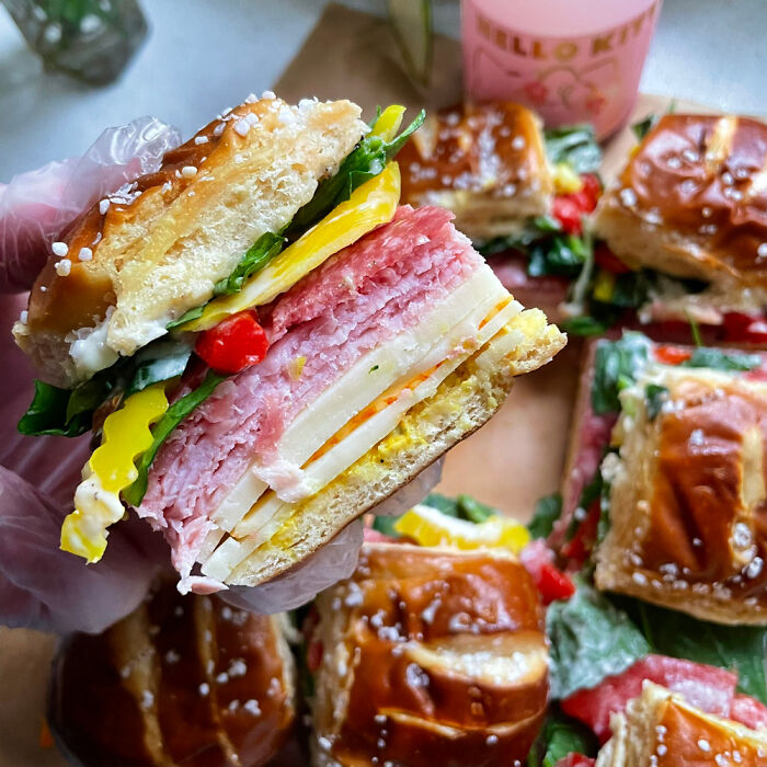 Pretzel Bun Sliders. Calabrian Chili Mayo, Mustard, Munster, Provlone, Rosemary Ham, Salami, Spinach, Banana Peppers, Basil