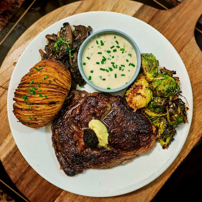 Rib-Eye Cooked Medium Rare, Bone-Marrow Hasselback Potatoes, Air Fried Garlic Parmesan Brussel Sprouts, Thyme And Sage Mushrooms, And Blue-Cheese Sauce [homemade]