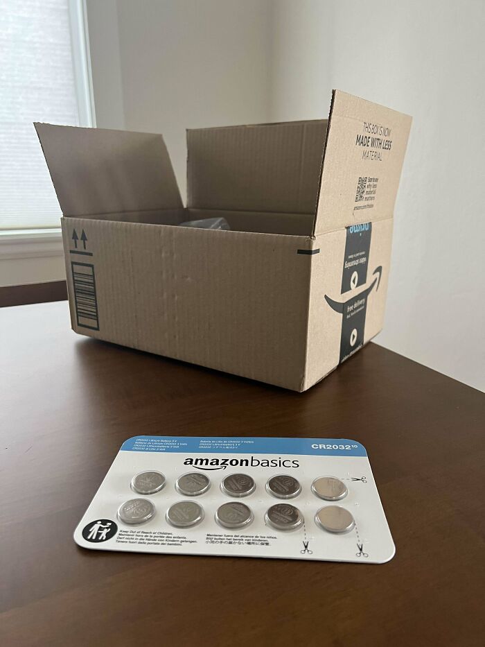 Oversized Amazon box packaging tiny batteries, highlighting wasteful product packaging.