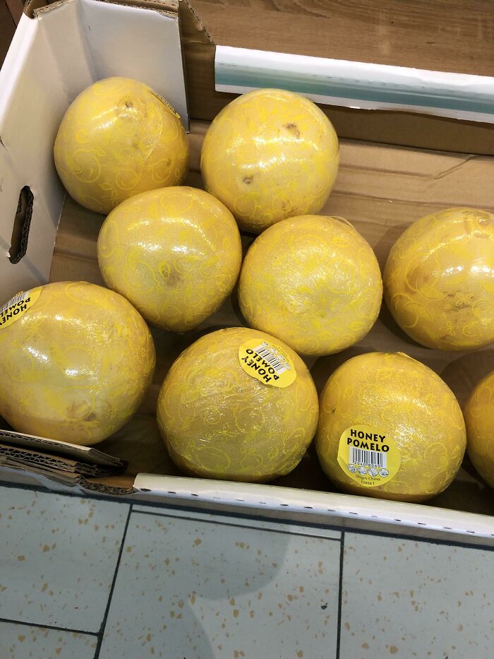 Honey Pomelos with misleading plastic packaging in a grocery box.