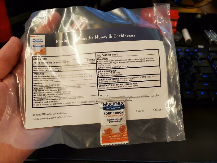 Product packaging error showcasing oversized instruction sheet with tiny Mucinex sample.