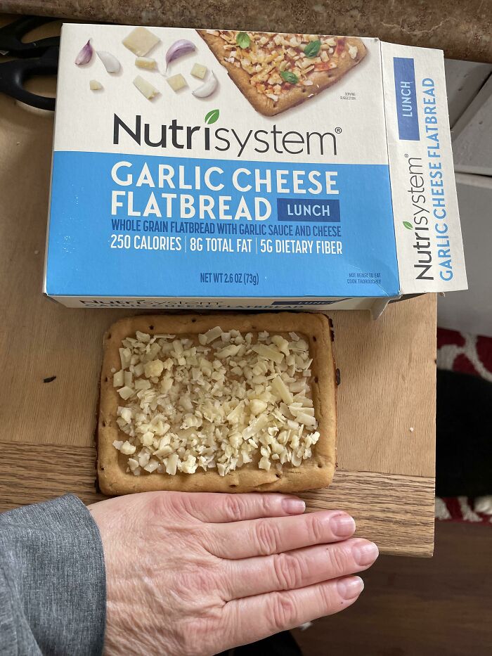 Nutrisystem garlic cheese flatbread packaging showing misleading topping image compared to actual product.