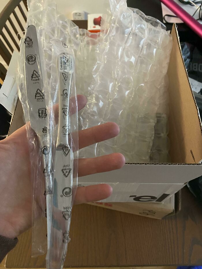 Excessive product packaging with bubble wrap for small item in a box, highlighting wasteful packaging practices.