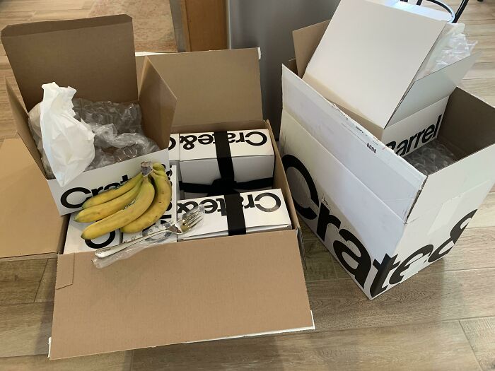 Excessive product packaging with large boxes, small items, and bananas, highlighting wasteful design for shaming.