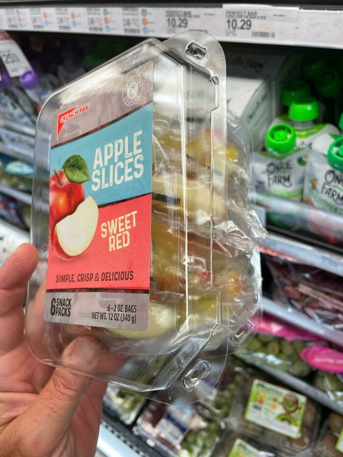 Product packaging fail; apple slices in excessive plastic container at grocery store.