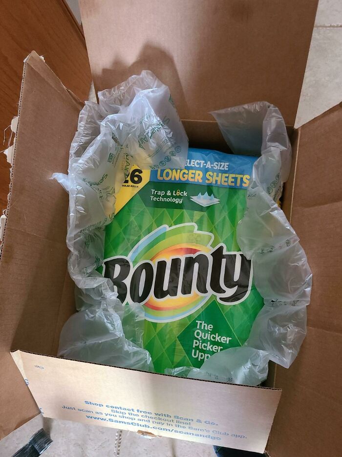 Excessive packaging for a single Bounty paper towel roll surrounded by air cushions in a large box.