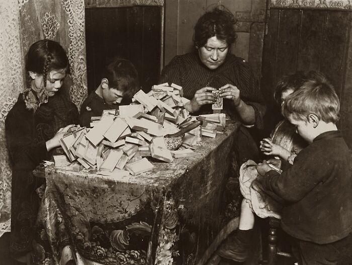 A Mother And Her Children Making Matchboxes