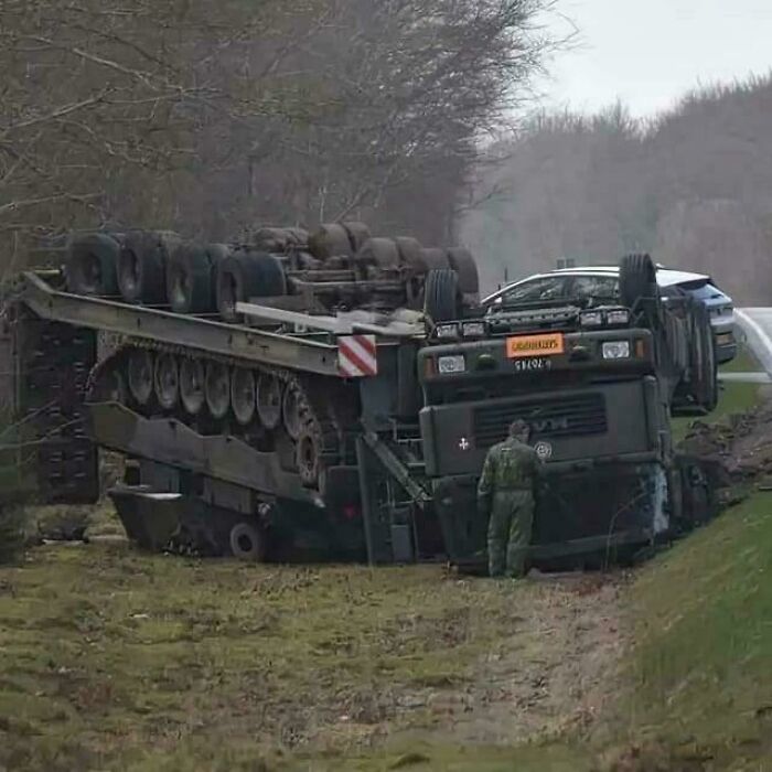 Truck overturned in a ditch with a tank on a trailer, highlighting an unfortunate incident likely costly.