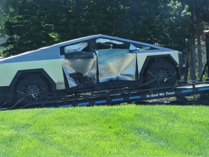 Damaged futuristic car on a tow truck, highlighting unfortunate incidents that looked expensive.