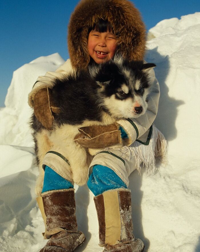 A Caribou Inuit Girl Holds Her Canadian Eskimo Puppy