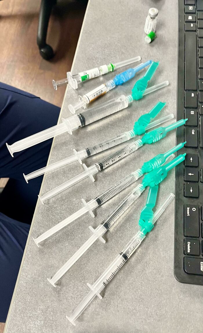 Medical syringes and vials on a desk next to a keyboard, highlighting intriguing medical cases and the human body's complexity.