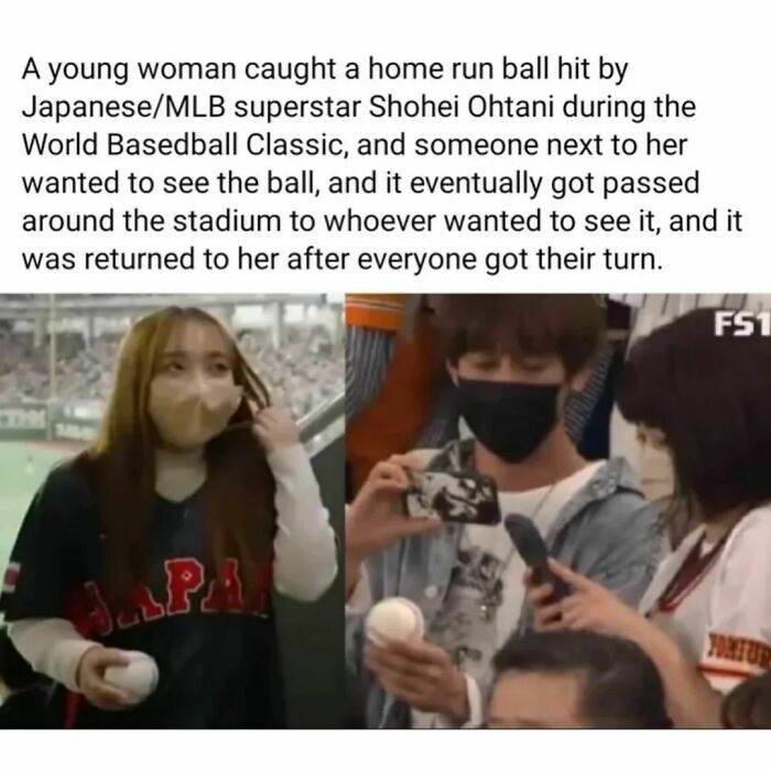 A woman in a Japan jersey holds a baseball happily at a stadium. Fans gather around, sharing the wholesome moment.