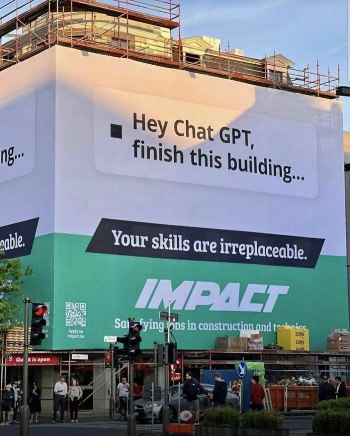 Billboard highlighting human importance in capitalism, with text: "Hey Chat GPT, finish this building. Your skills are irreplaceable."