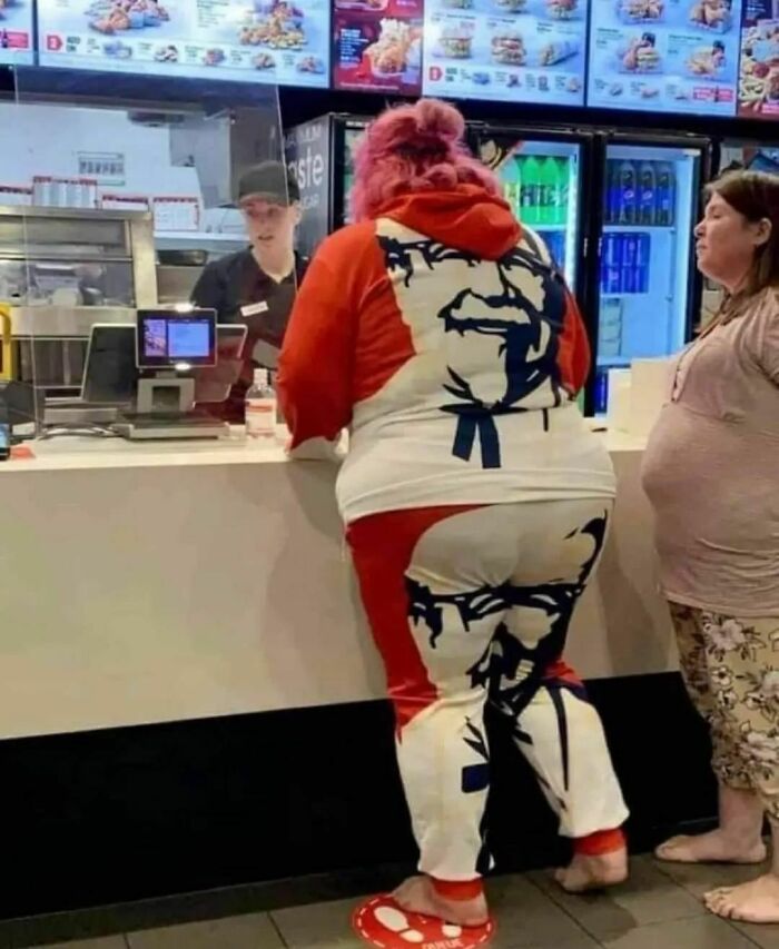 Person in fast-food restaurant wearing a Colonel Sanders tracksuit, illustrating humans of capitalism pictures.