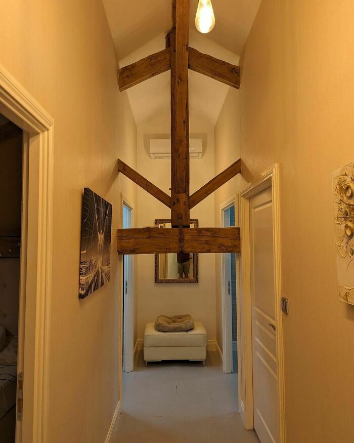 Hallway with awkward wooden beam installation, illustrating a design disaster.