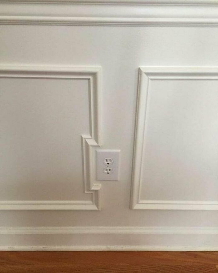 Bad design with a wall outlet interrupting decorative paneling, showcasing a design disaster deserving to be shamed.