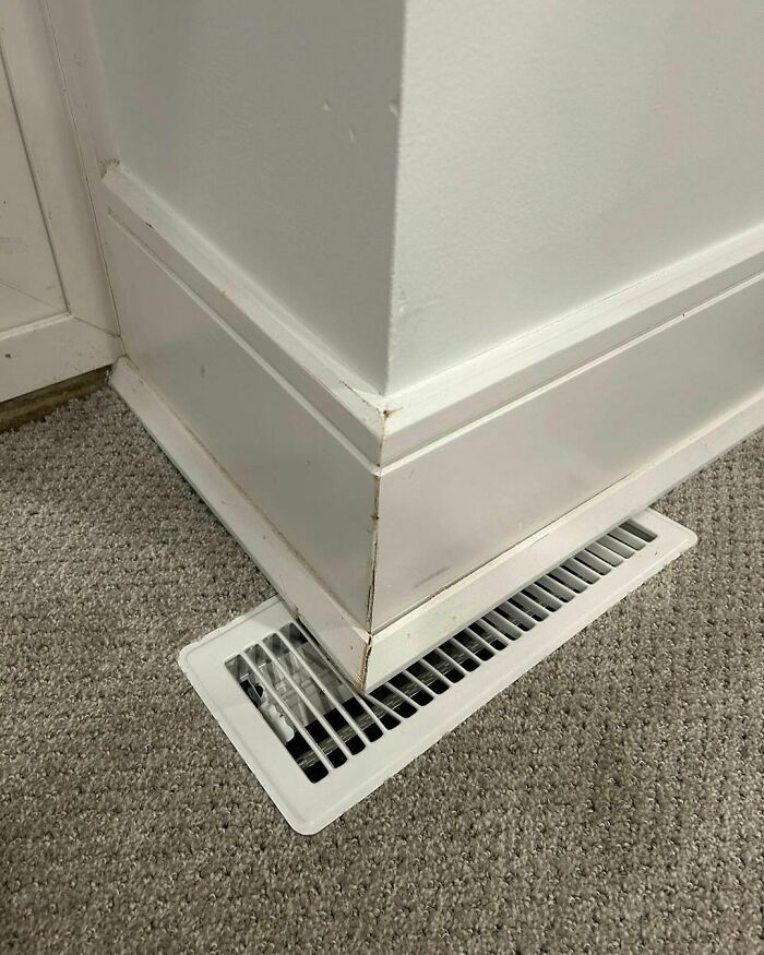 Design disaster showing a poorly placed floor vent partially covered by a wall corner.