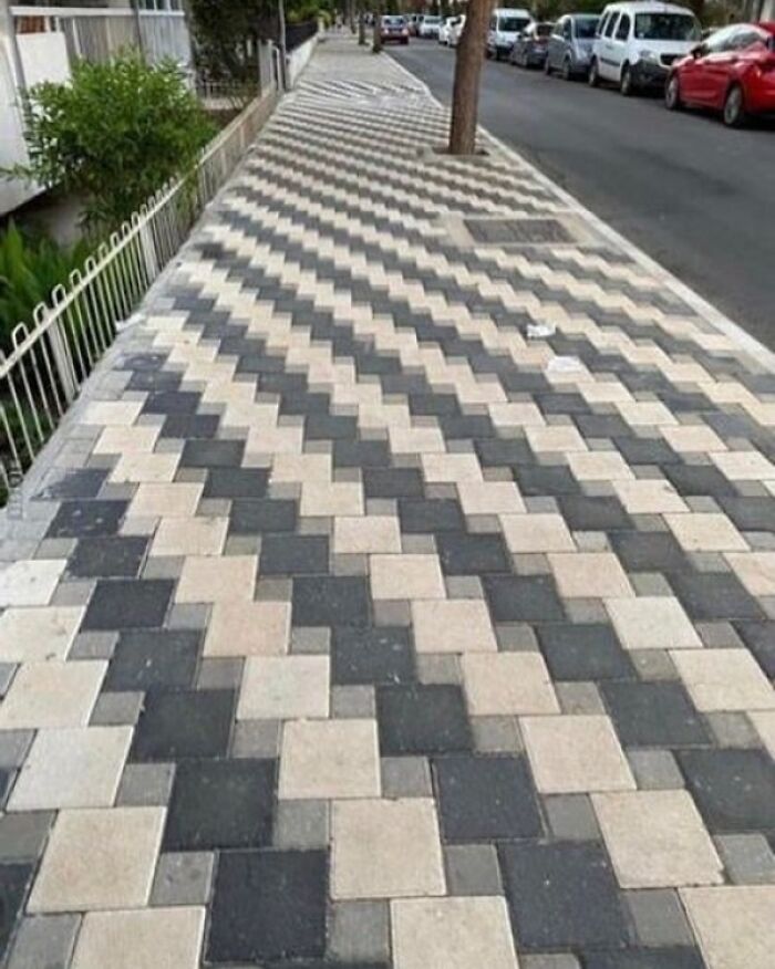 Sidewalk with optical illusion pattern, showcasing a design disaster deserving criticism.