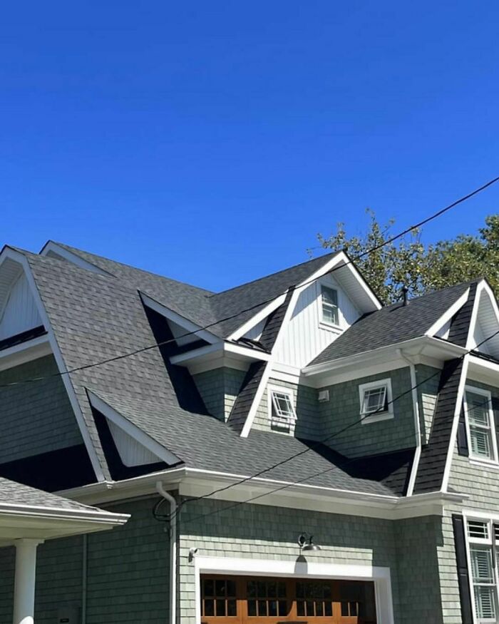 House with multiple overlapping roofs, showcasing a design disaster.