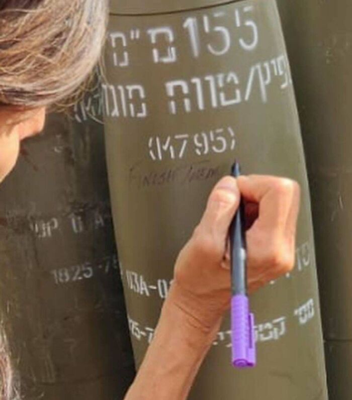 Person writing on a large green object with a purple pen, suggesting a boring dystopia.