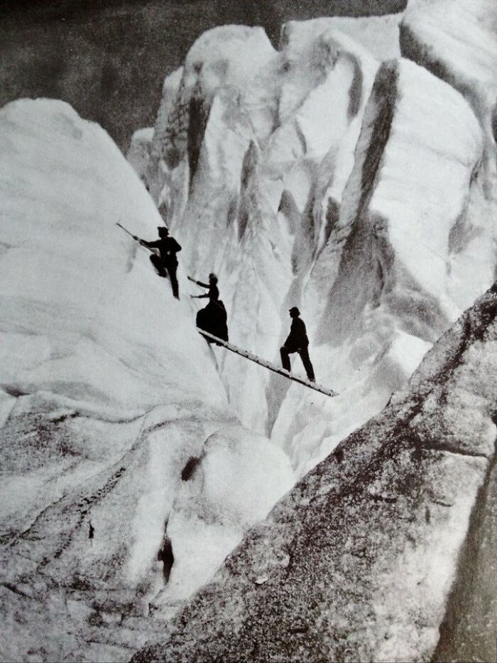 Late Victorian Mountaineers, Including A Lady Fully Dressed And Corseted, Cross A Crevasse In The Alps, 1900