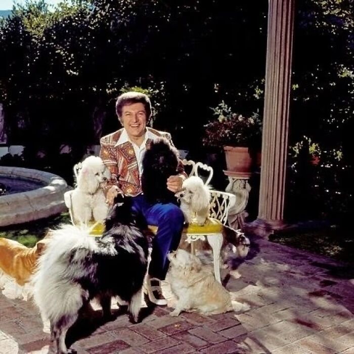 Liberace Poses Alongside His Beloved Dogs At His Palm Springs Estate In September 1980