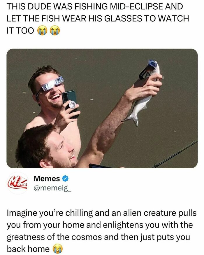 Two men fishing during eclipse; one holds a fish with glasses, creating a random yet hilarious meme moment.