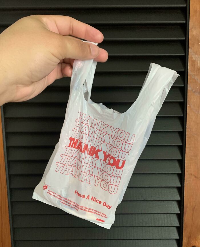 A hand holding a plastic bag covered in the words 'Thank You' written multiple times, humorously emphasizing repeated gratitude in everyday life.