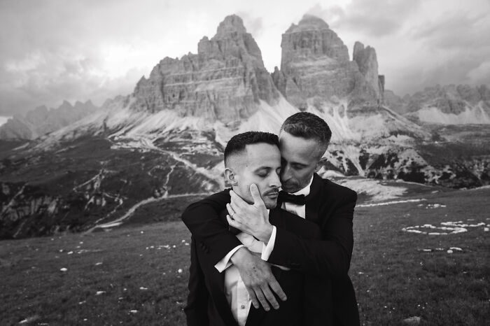 A couple embraces in front of mountain landscape, showcasing top destination wedding photos of 2024.