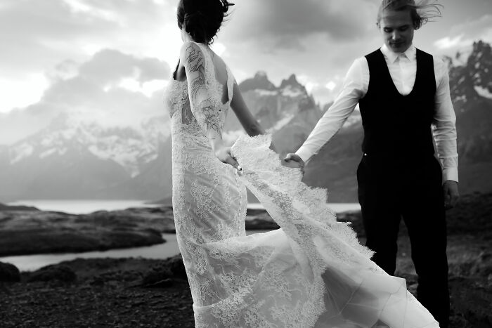 Couple at a scenic destination wedding with mountains in the background, capturing a romantic moment.