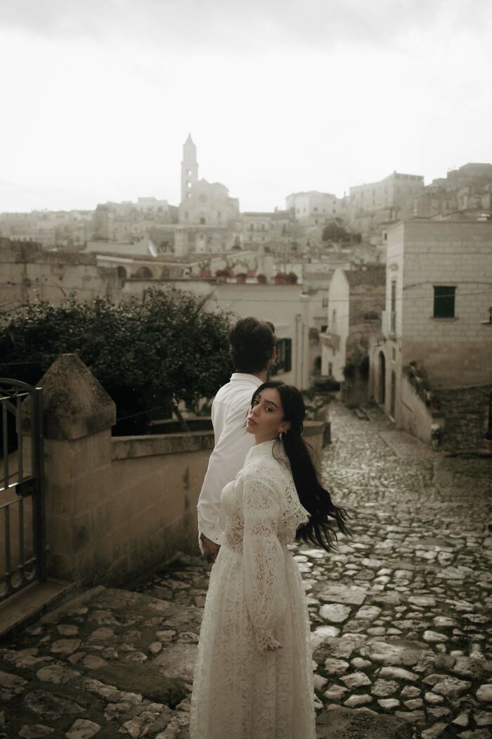 Couple in elegant attire on a cobblestone street, showcasing top destination wedding photography of 2024.