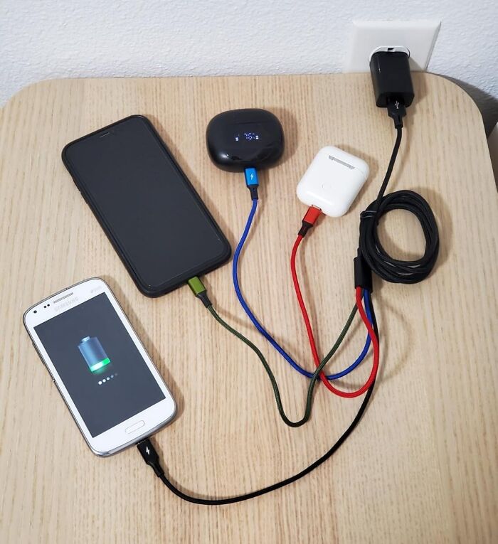 Mini items charging on a wooden table, ideal for minimalist packing in a carry-on.