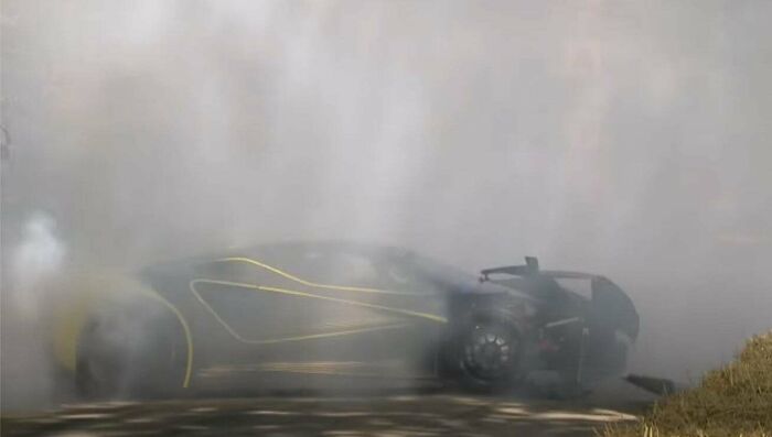 Luxury car crash amidst smoke, likely a costly incident.