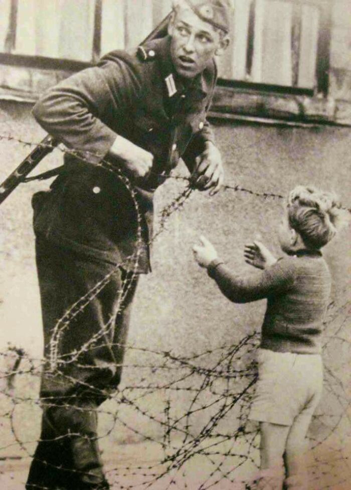 Increíble fotografía de un soldado alemán que desobedeció órdenes directas para ayudar a un niño a cruzar el recién formado Muro de Berlín después de ser separado de su familia, 1961