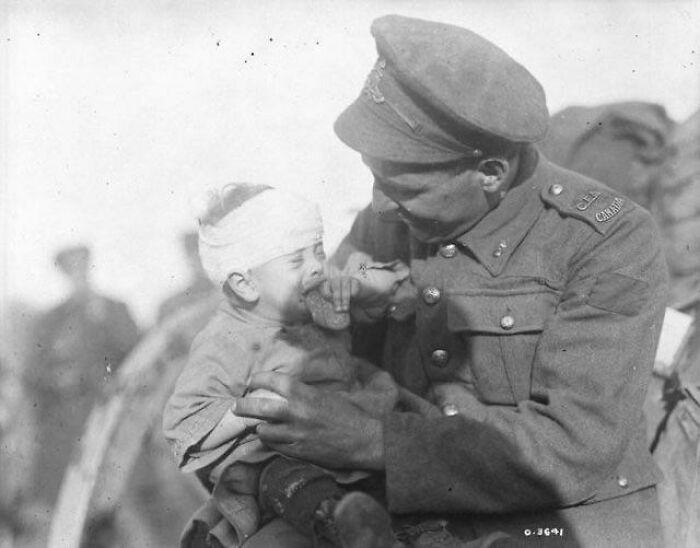 Primera Guerra Mundial. Un soldado canadiense intenta consolar a un bebé belga que resultó herido y cuya madre murió a causa de un proyectil de artillería. Noviembre de 1918